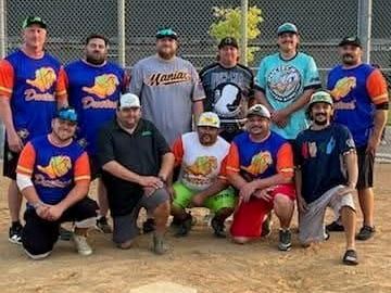 Men's adult softball team. 11 men standing behind home plate. 