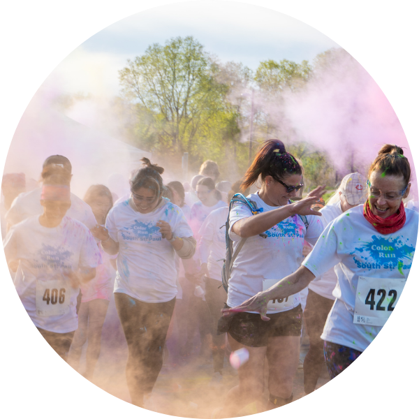 Group of runners throwing colored powder in the air during the 5K Color Run
