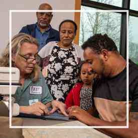 A family learning how to sew